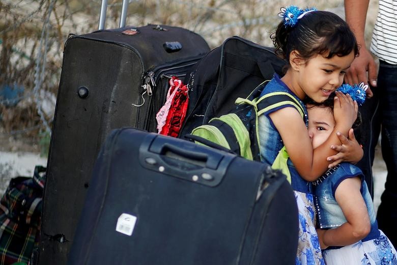 A girl hugs her sister as she cries before they leave the Palestinian Rafah border crossing with Egypt, which was reopened for the first time since it was closed in March due to concerns about the spread of the coronavirus, in the southern Gaza Strip. REUTERS/Mohammed Salem  